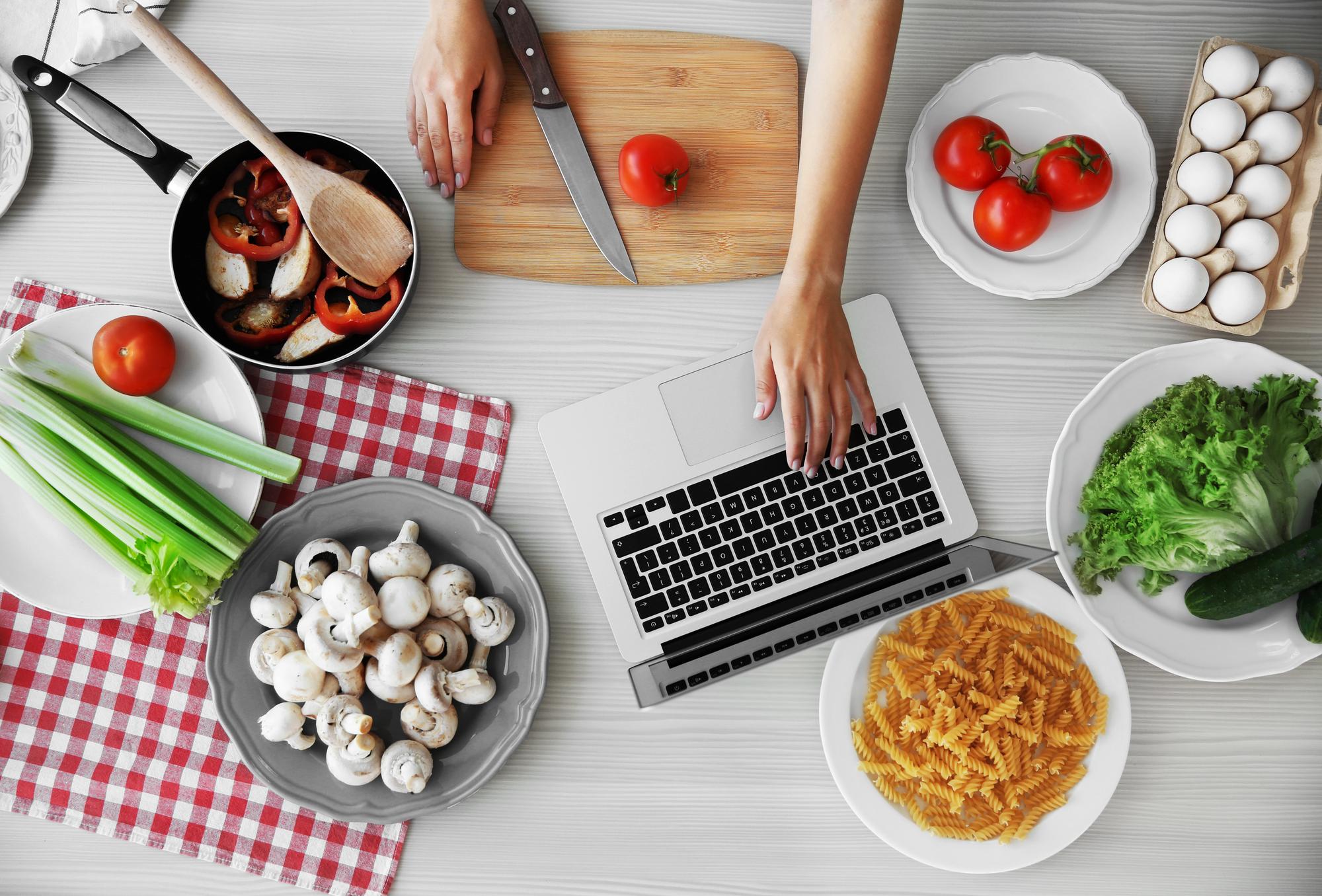 Scatto lifestyle di una lezione di cucina online con laptop e ingredienti