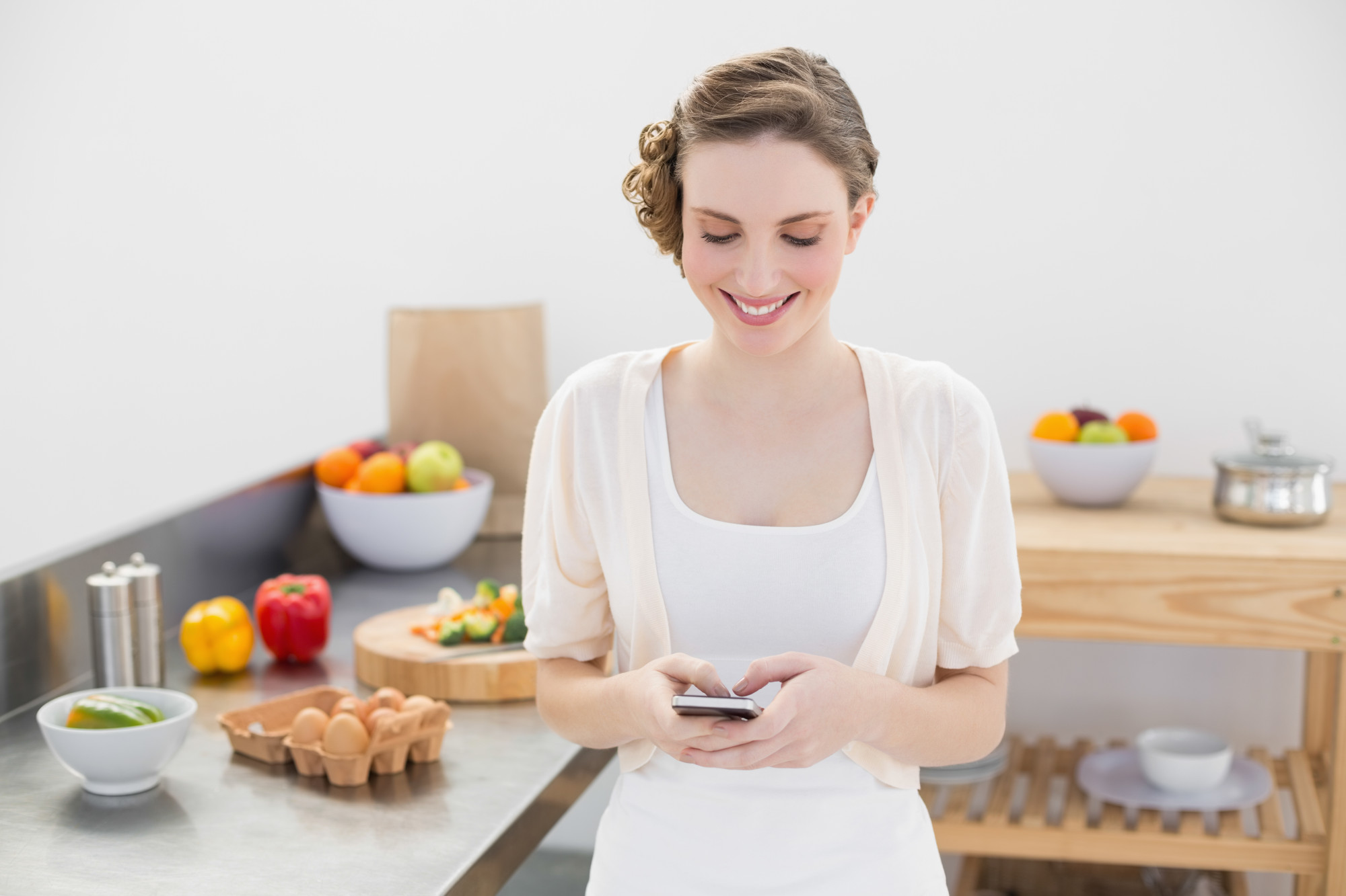 Persona che consulta una ricetta su smartphone in cucina